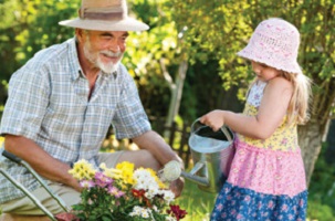 grandfather gardening with granddaughter